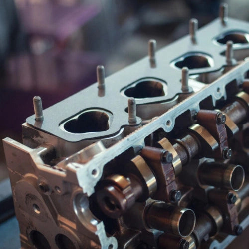 Close-up of a metallic engine block with pipes and bolts.