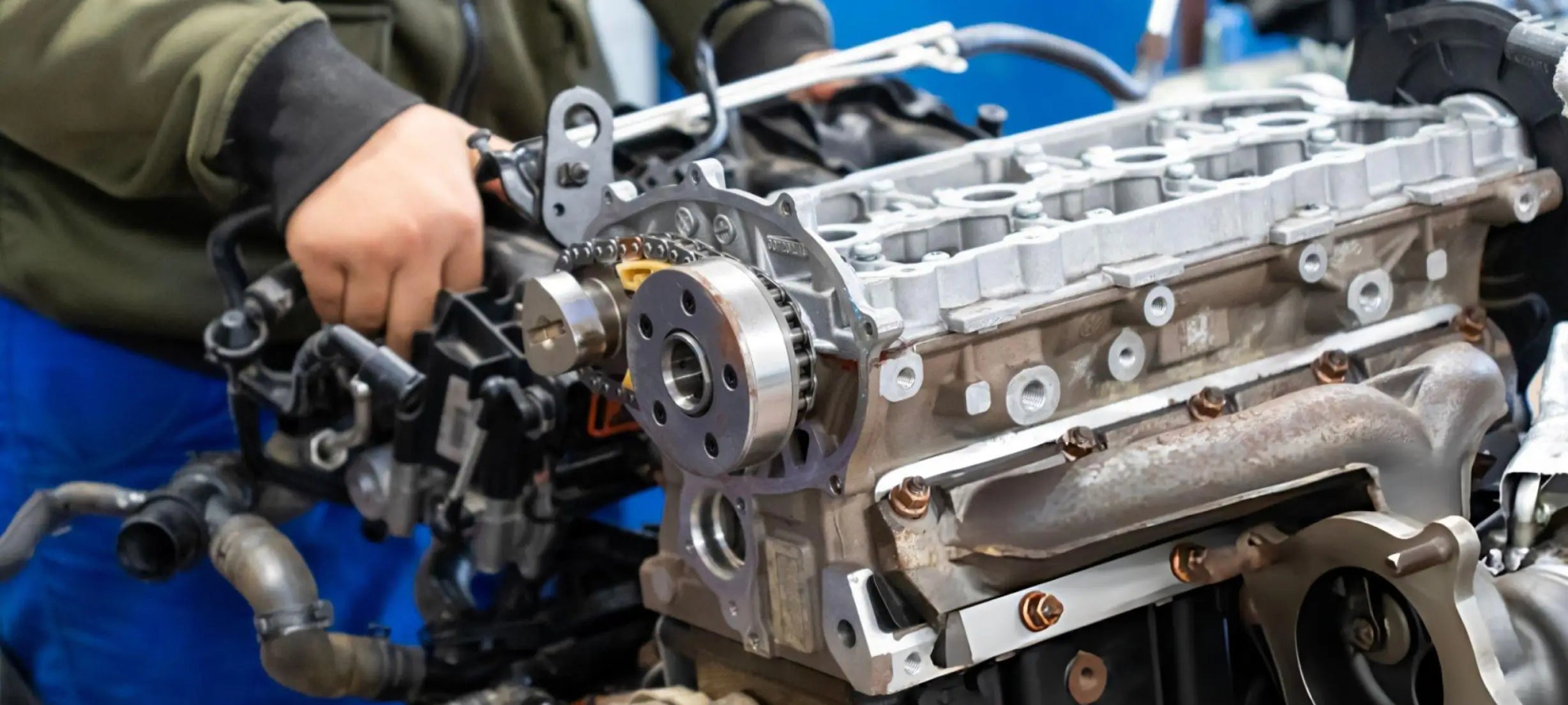 Engine block with mechanical parts and a person's hand holding it, on a blue background