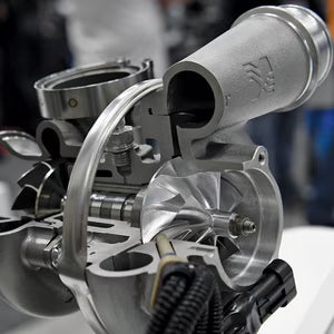 Close-up of a turbocharger with visible branding on a blurred background