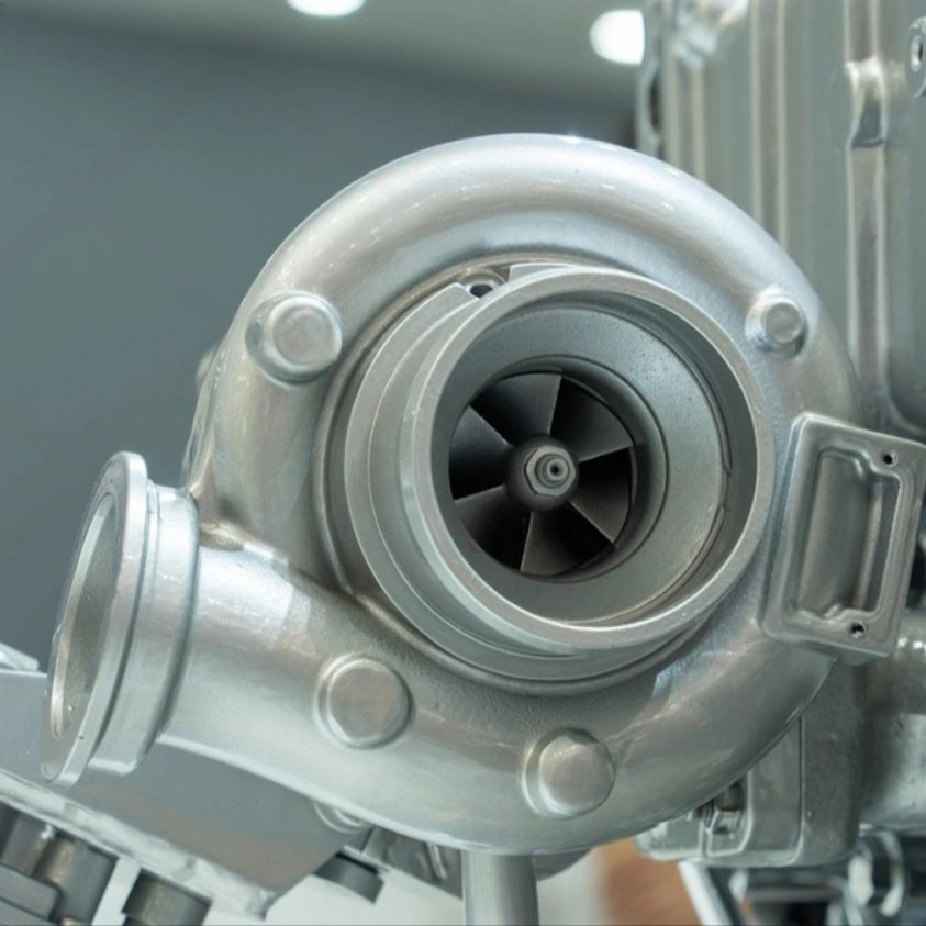 Close-up of a metallic turbocharger on a blurred background